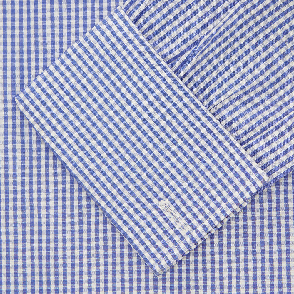 The Turnbull & Asser Mid Blue Gingham Check Shirt features a T&A collar, double cuffs, and white buttons, neatly displayed against a plain white background.