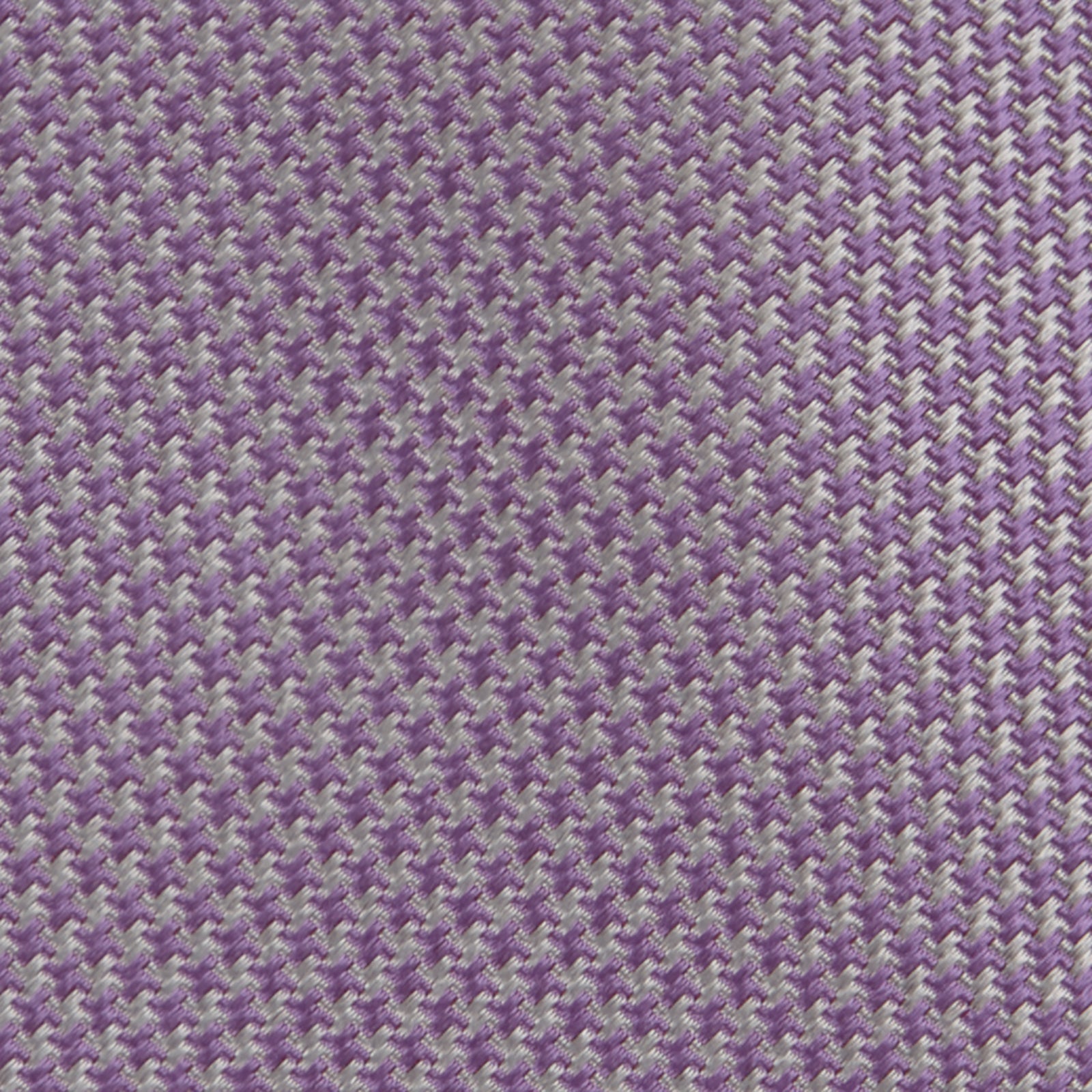 View 3 of product The Turnbull & Asser Lilac Houndstooth Silk Tie features a subtle houndstooth pattern and elegant silk weave—ideal for elevating your favorite office shirt. Displayed rolled on a white background.