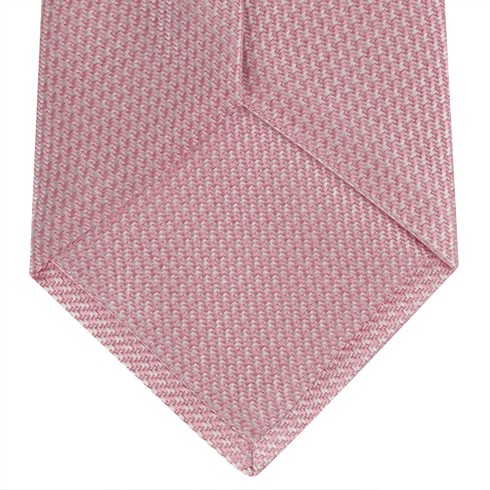 The Turnbull & Asser Pink Houndstooth Silk Tie, featuring a subtle textured pattern, is rolled up and displayed on a plain white background—ideal for pairing with your favorite office shirt.