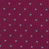 View 3 of product The Turnbull & Asser Dark Pink and Blue Spot Lace Silk Tie features small, evenly spaced blue dots on dark pink silk, shown rolled up against a white background.
