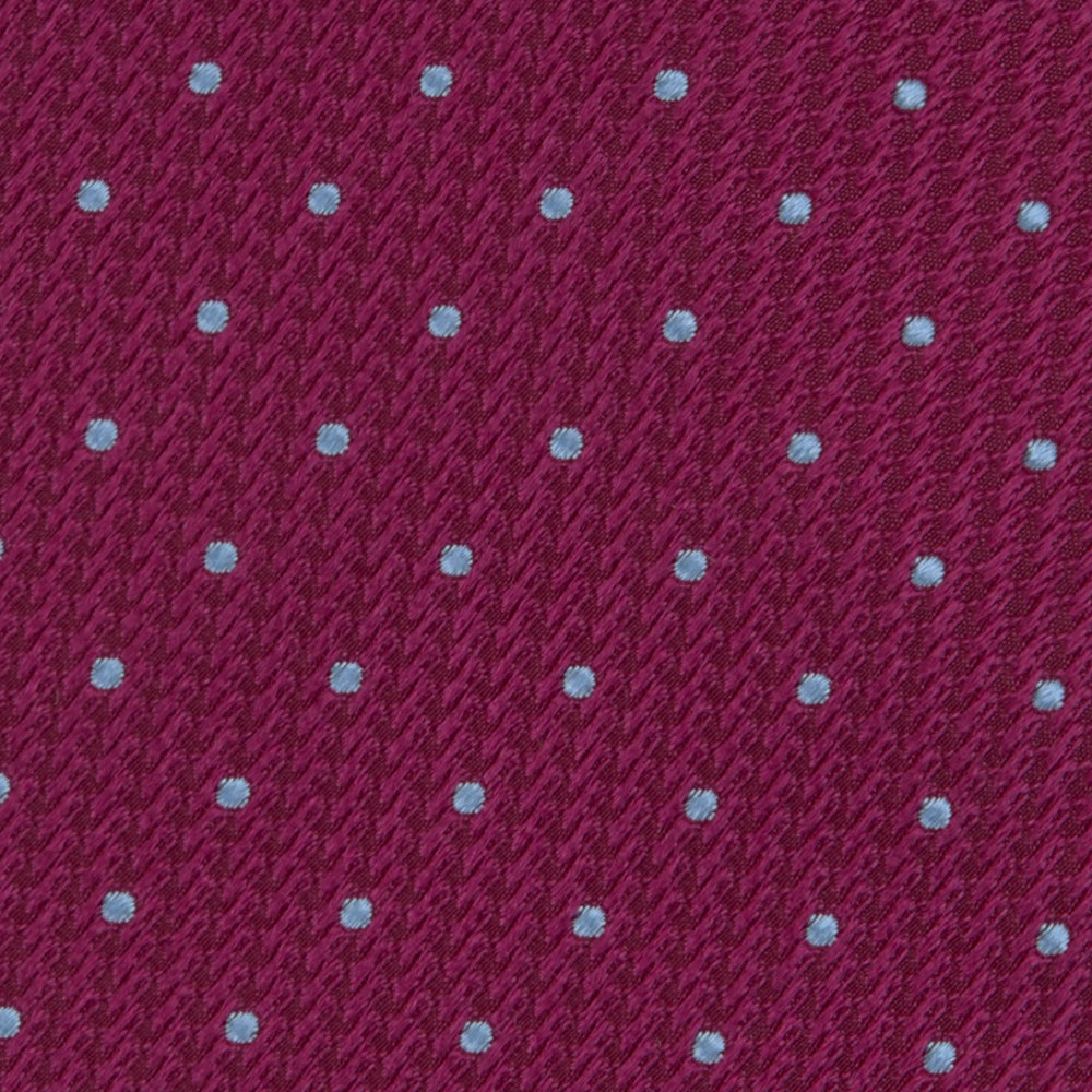 The Turnbull & Asser Dark Pink and Blue Spot Lace Silk Tie features small, evenly spaced blue dots on dark pink silk, shown rolled up against a white background.