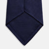 View 4 of product The Turnbull & Asser Slim Navy Herringbone Silk Tie is a refined men’s accessory, elegantly rolled and displayed on a plain white background.