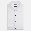 View 5 of product The Casino Royale White Dress Shirt in Cotton by Turnbull & Asser UK is a long-sleeve white dress shirt, crafted from crisp white cotton poplin with a pleated bib front, black buttons, and a classic collar, shown laid flat on a white background.