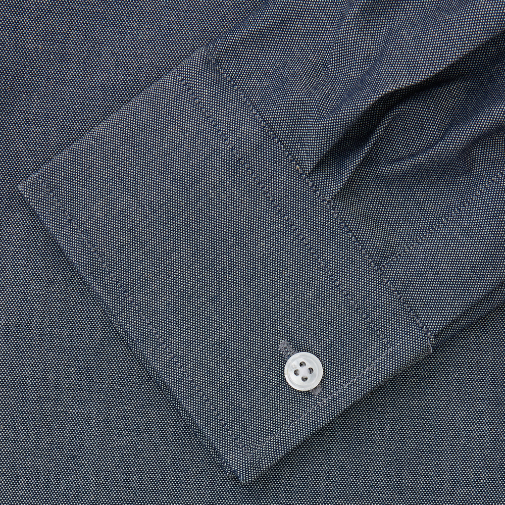 The Turnbull & Asser Plain Blue Oxford Weekend Fit Shirt features a Derby collar, 1-button cuffs, and a smart-casual look—perfect for weekends. Displayed flat on a white background.