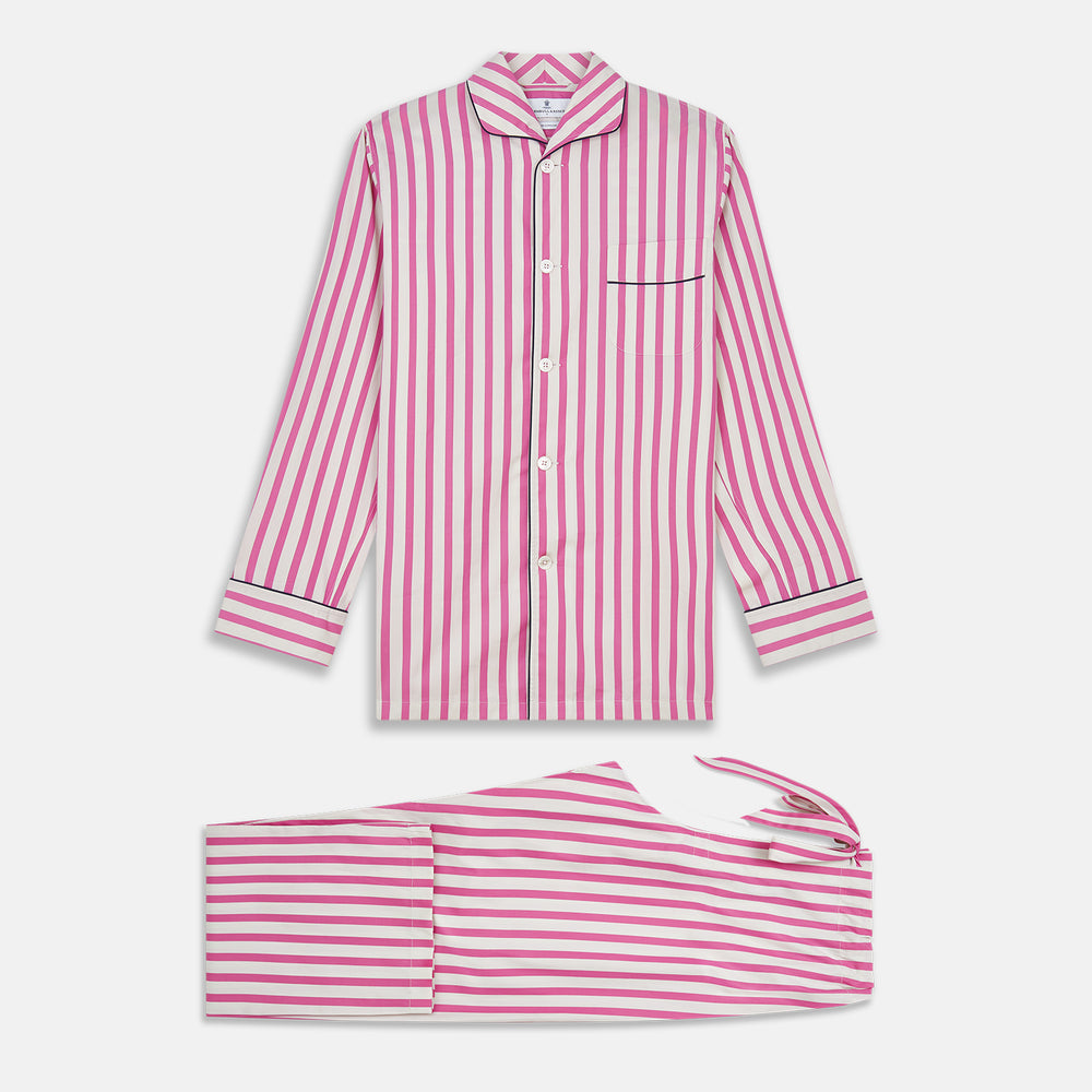 The Turnbull & Asser Pink Candy Stripe Cotton Traditional Pyjamas feature long sleeves, pants, vertical pink candy stripes, a camp collar shirt with buttons, chest pocket, and navy trim on the pocket and cuffs.
