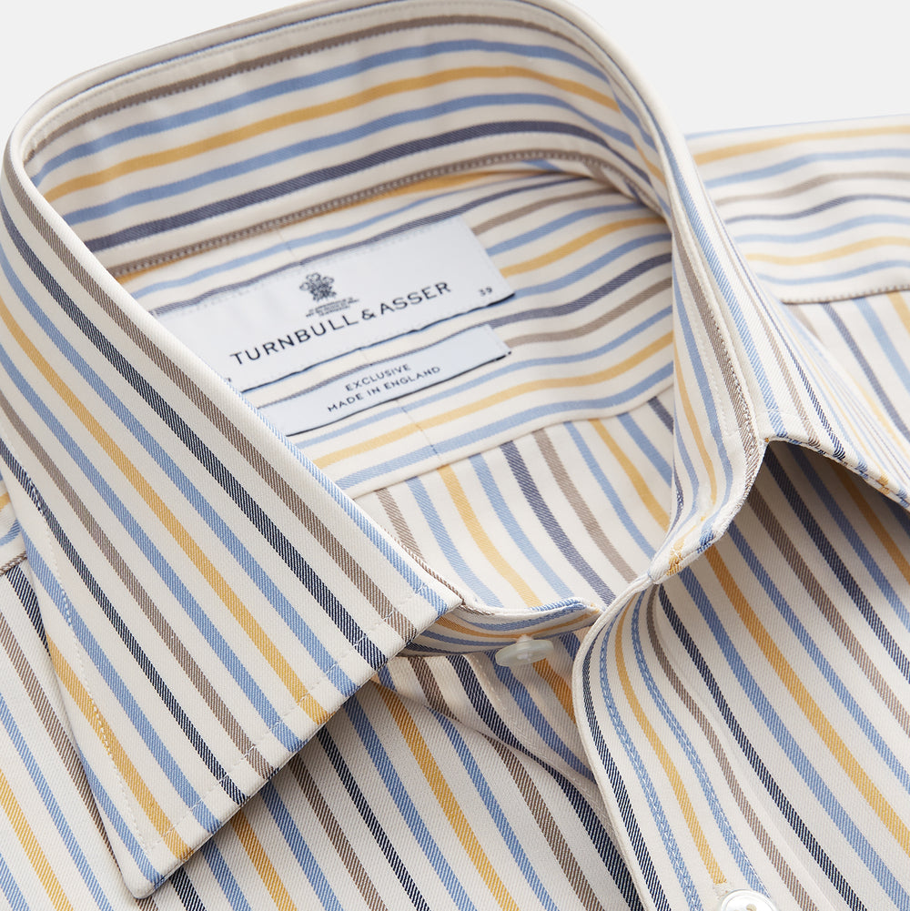 The Turnbull & Asser Yellow Multi Stripe Regular Fit Shirt features a T&A collar, 3 button cuffs, and thin blue, yellow, and light brown stripes on white for a classic formal look.