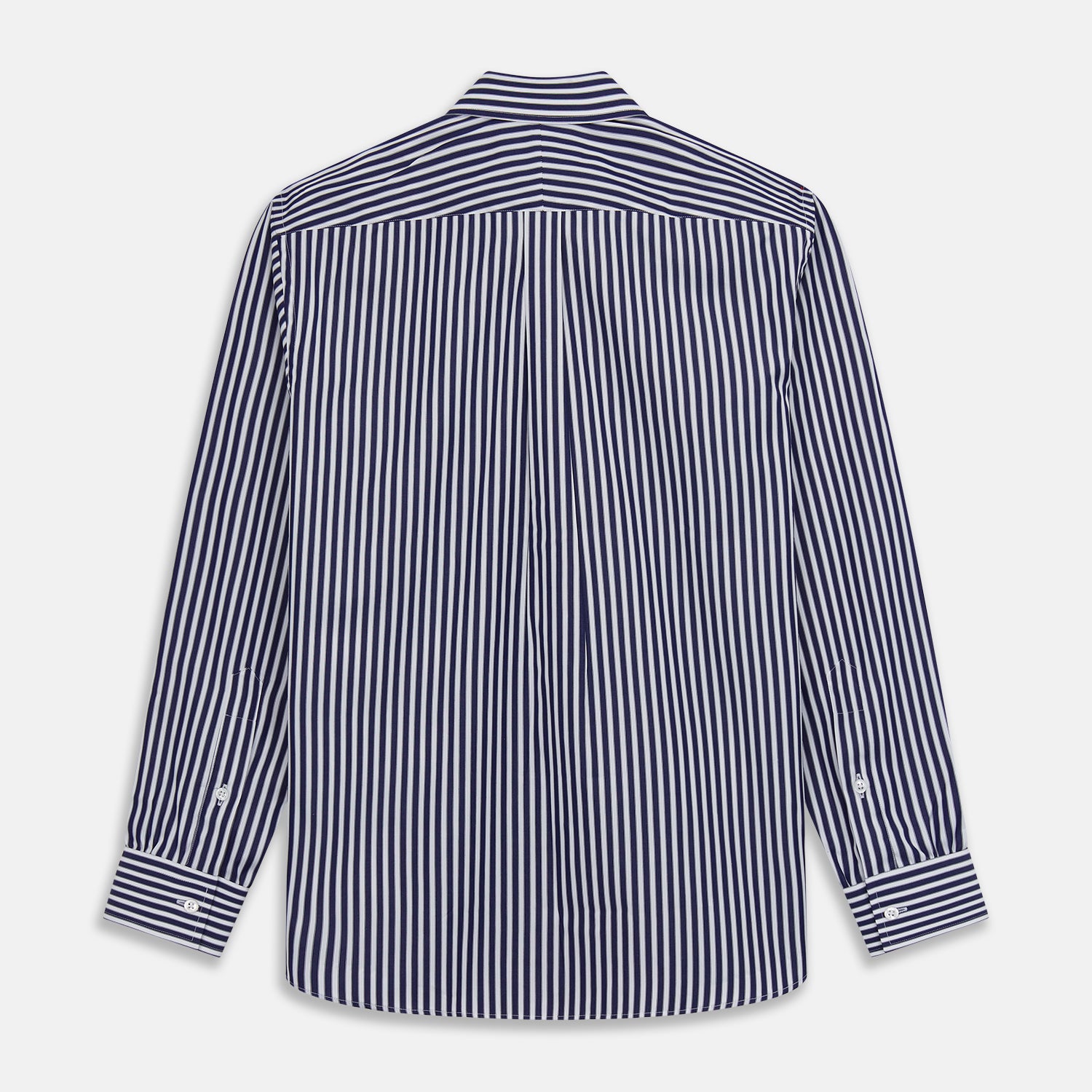 View 6 of product A person in a Turnbull & Asser Navy & White Stripe Weekend Fit Shirt with Derby Collar and Single Button Cuffs, paired with a paisley tie and dark pants, stands indoors leaning against a cream paneled wall.
