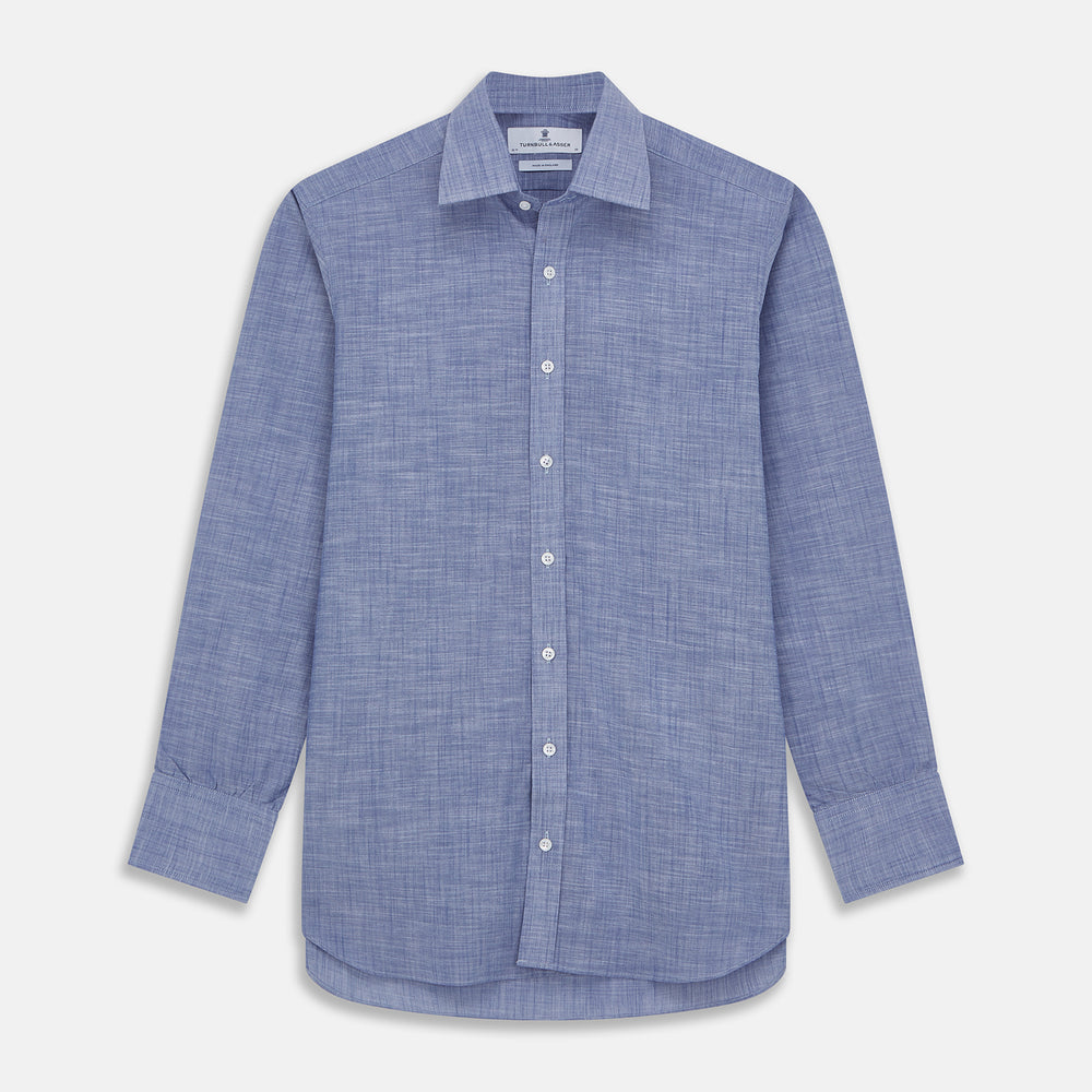 The Turnbull & Asser Blue Chambray Cotton Regular Fit Mayfair Shirt features a subtle textured pattern, pointed T&A collar, and white buttons. Shown here in a light blue shade, laid flat on a white background.