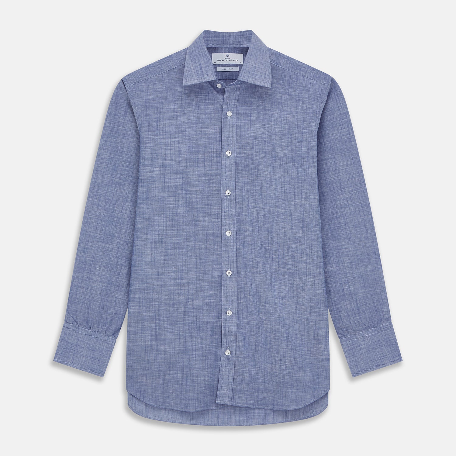 View 1 of product The Turnbull & Asser Blue Chambray Cotton Regular Fit Mayfair Shirt features a subtle textured pattern, pointed T&A collar, and white buttons. Shown here in a light blue shade, laid flat on a white background.