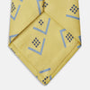 View 3 of product The Turnbull & Asser Yellow Graphic Deco Silk Tie features a subtle pattern of light blue geometric shapes and small black dots, elegantly rolled against a white background.