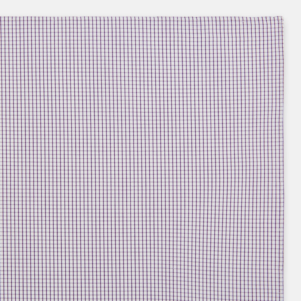 The Turnbull & Asser Hand Rolled Purple Graph Check Handkerchief features a purple checkered grid pattern on white cotton, neatly folded and displayed on a plain surface—a refined accessory for any formal occasion.