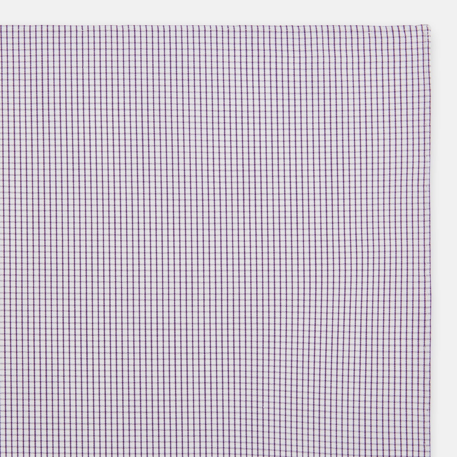 View 2 of product The Turnbull & Asser Hand Rolled Purple Graph Check Handkerchief features a purple checkered grid pattern on white cotton, neatly folded and displayed on a plain surface—a refined accessory for any formal occasion.