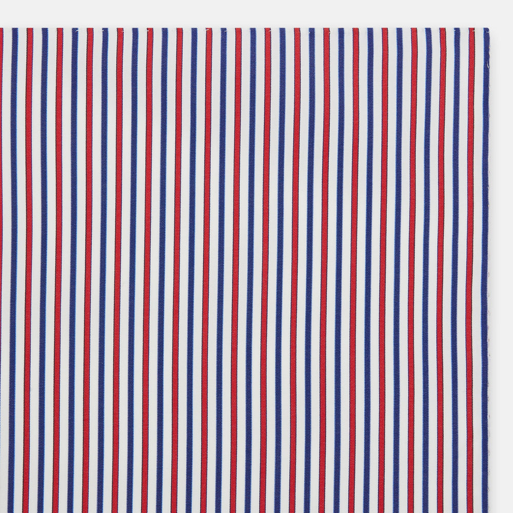 The Hand Rolled Red and Blue Track Stripe Handkerchief by Turnbull & Asser features vertical red, blue, and white stripes—a refined cotton accessory with a visible seam, ideal for formal occasions.