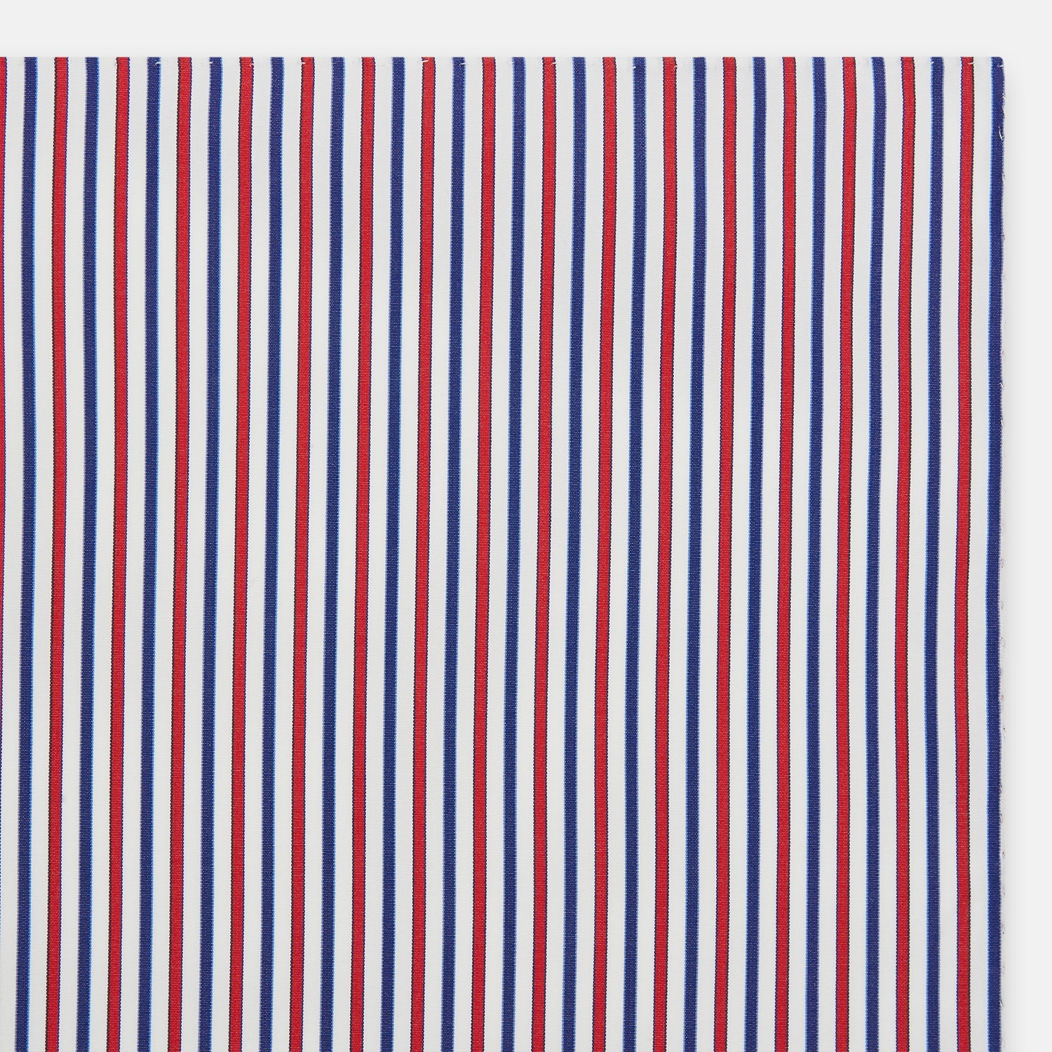 View 2 of product The Hand Rolled Red and Blue Track Stripe Handkerchief by Turnbull & Asser features vertical red, blue, and white stripes—a refined cotton accessory with a visible seam, ideal for formal occasions.