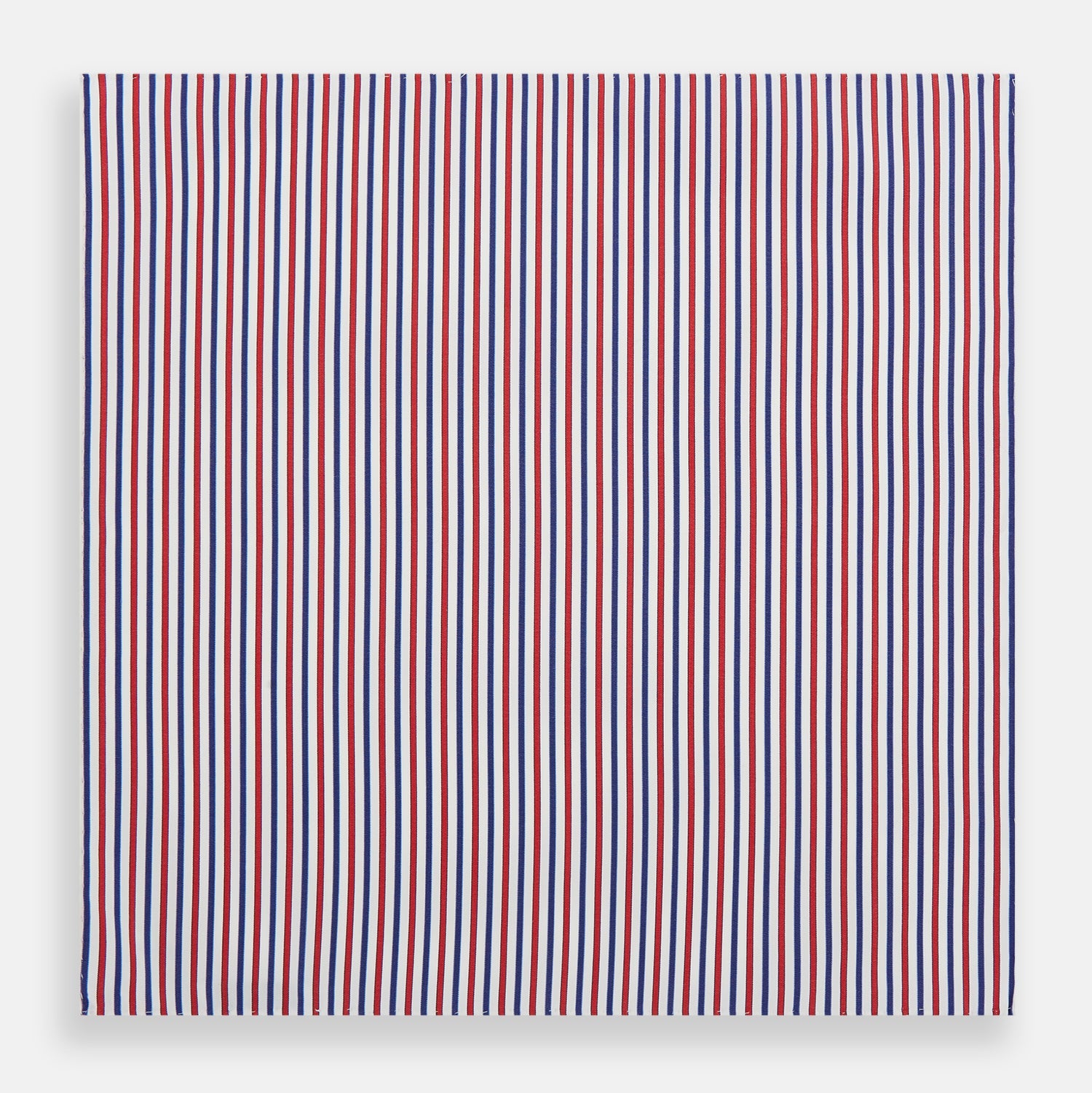 View 3 of product The Hand Rolled Red and Blue Track Stripe Handkerchief by Turnbull & Asser features vertical red, blue, and white stripes—a refined cotton accessory with a visible seam, ideal for formal occasions.