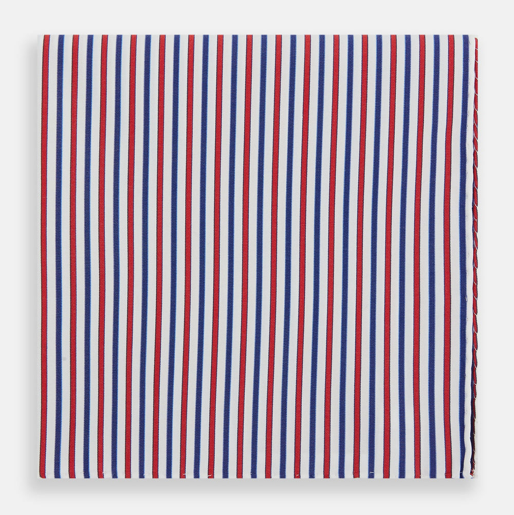 The Hand Rolled Red and Blue Track Stripe Handkerchief by Turnbull & Asser features vertical red, blue, and white stripes—a refined cotton accessory with a visible seam, ideal for formal occasions.