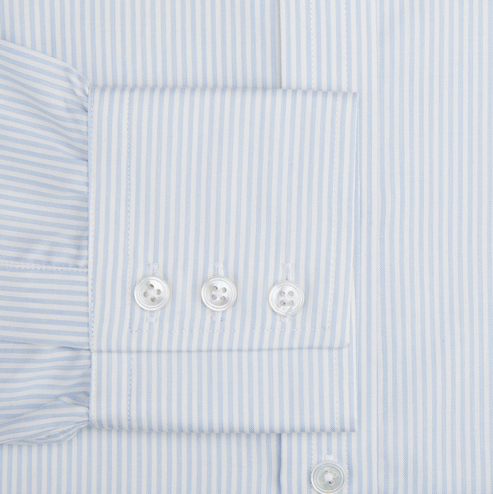 The Turnbull & Asser Blue and White Pencil Stripe Cashmerello Mayfair Shirt features a pointed collar, white buttons, buttoned cuffs, and long sleeves. Crafted from a cotton-cashmere blend, it’s displayed flat on a white background.