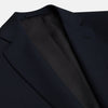 View 2 of product The Midnight Navy Wool Barrington Blazer by Turnbull & Asser features a single-breasted design with notched lapels, three front flap pockets, one chest pocket, and a two-button closure, neatly laid flat against a white background.