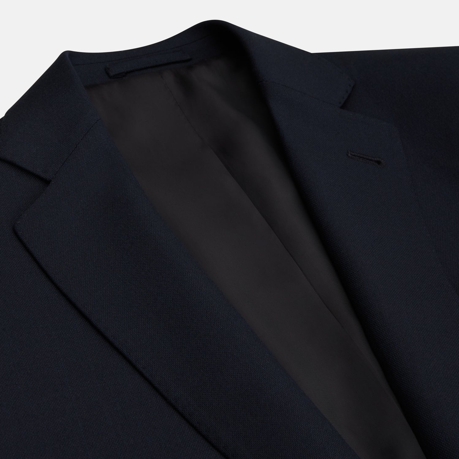 View 2 of product The Midnight Navy Wool Barrington Blazer by Turnbull & Asser features a single-breasted design with notched lapels, three front flap pockets, one chest pocket, and a two-button closure, neatly laid flat against a white background.