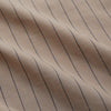View 6 of product An older man in a light hat, Turnbull & Asser Beige Stripe Cotton Holiday Fit Shirt with Revere Collar & Single Button Cuff, and white pants leans casually against a tall concrete pillar outdoors, greenery blurred behind him.