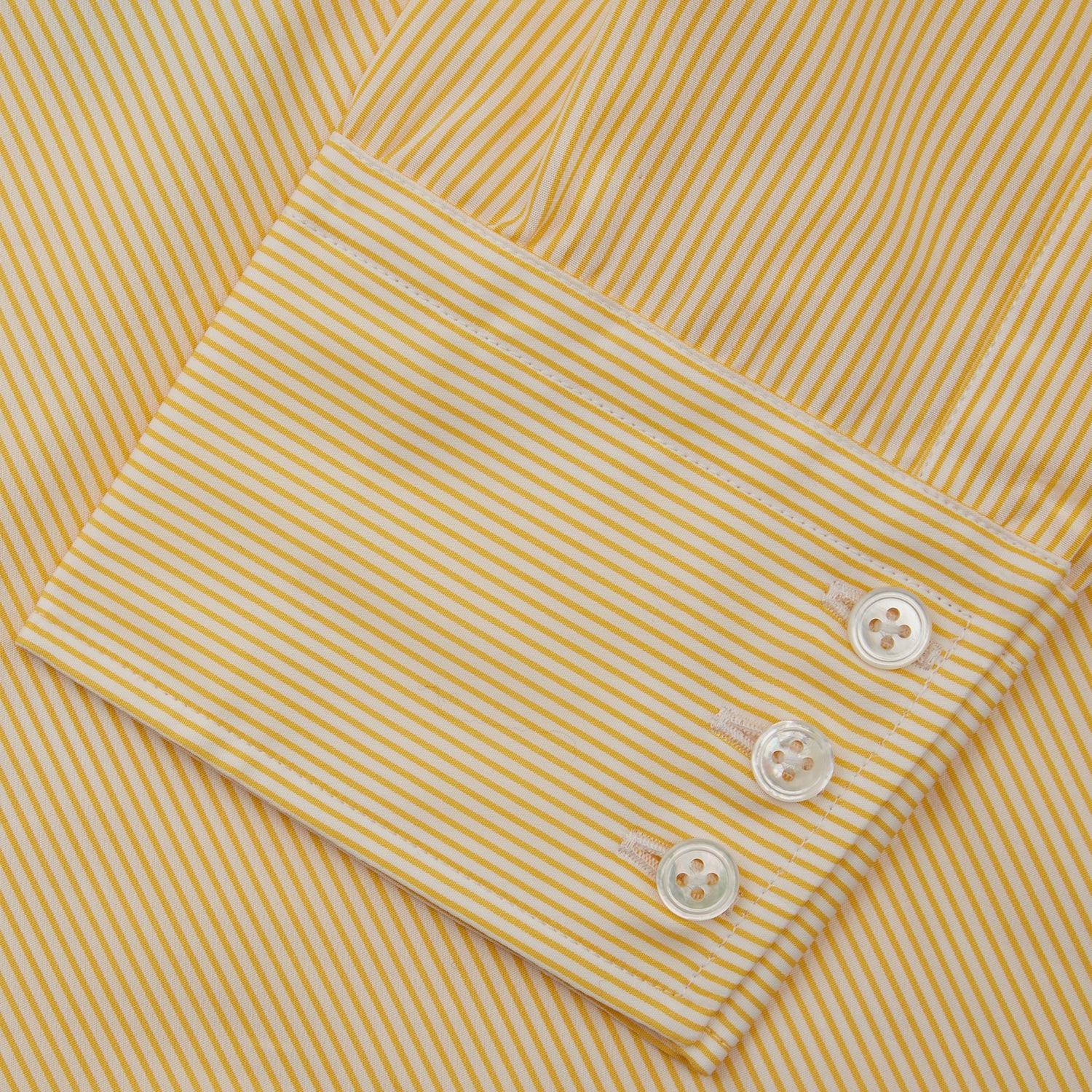 View 3 of product The Turnbull & Asser Yellow Fine Stripe Regular Fit Shirt with T&A Collar features long sleeves, a button-down front, and buttoned cuffs, crafted from fine Italian cotton and shown against a white background.