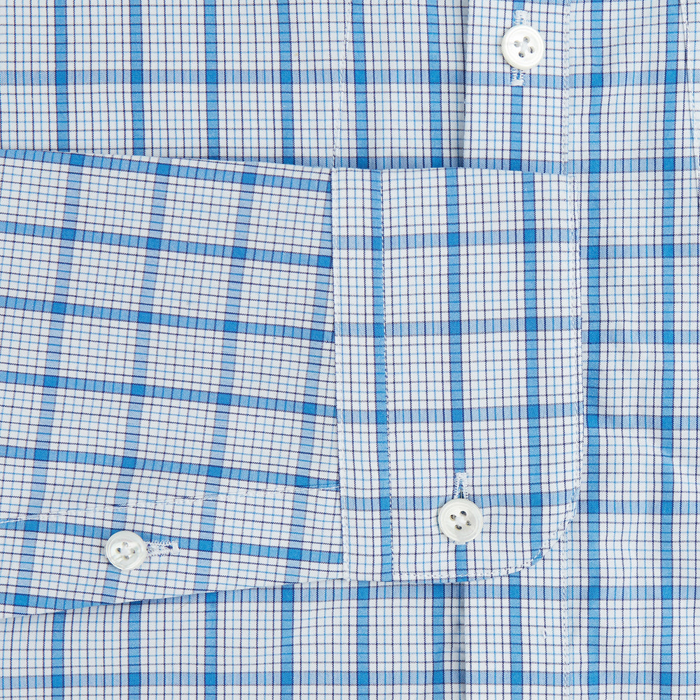 The Turnbull & Asser Blue Graph Overlay Check Piccadilly Shirt is a breathable cotton button-up featuring a collar, two chest pockets, white buttons, and an elegant blue graph check—perfect for the holidays.
