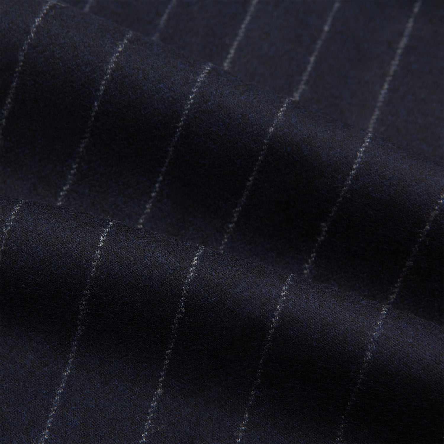 View 6 of product The Navy Pinstripe Henry Trousers by Turnbull & Asser feature vertical white stripes, a tailored fit, button closure, and belt loops. Crafted from a wool cashmere blend, they are shown against a plain white background.