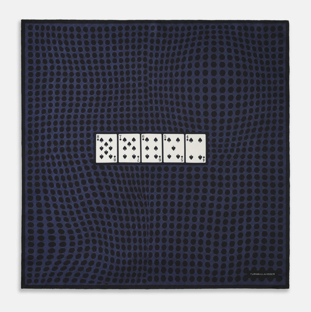 The Casino Royale Midnight Blue Straight Flush Pocket Square in Silk by Turnbull & Asser UK features a rich midnight blue background adorned with a black dotted pattern and showcases five playing cards—the 10, 9, 8, 7, and 6 of spades—arranged in a row at the center for an elegant straight flush design inspired by classic casino style.