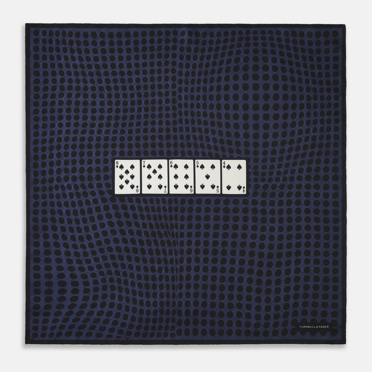 View 1 of product The Casino Royale Midnight Blue Straight Flush Pocket Square in Silk by Turnbull & Asser UK features a rich midnight blue background adorned with a black dotted pattern and showcases five playing cards—the 10, 9, 8, 7, and 6 of spades—arranged in a row at the center for an elegant straight flush design inspired by classic casino style.