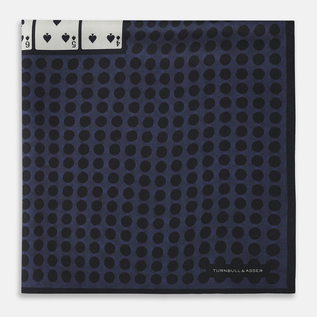 View 4 of product The Casino Royale Midnight Blue Straight Flush Pocket Square in Silk by Turnbull & Asser UK features a rich midnight blue background adorned with a black dotted pattern and showcases five playing cards—the 10, 9, 8, 7, and 6 of spades—arranged in a row at the center for an elegant straight flush design inspired by classic casino style.