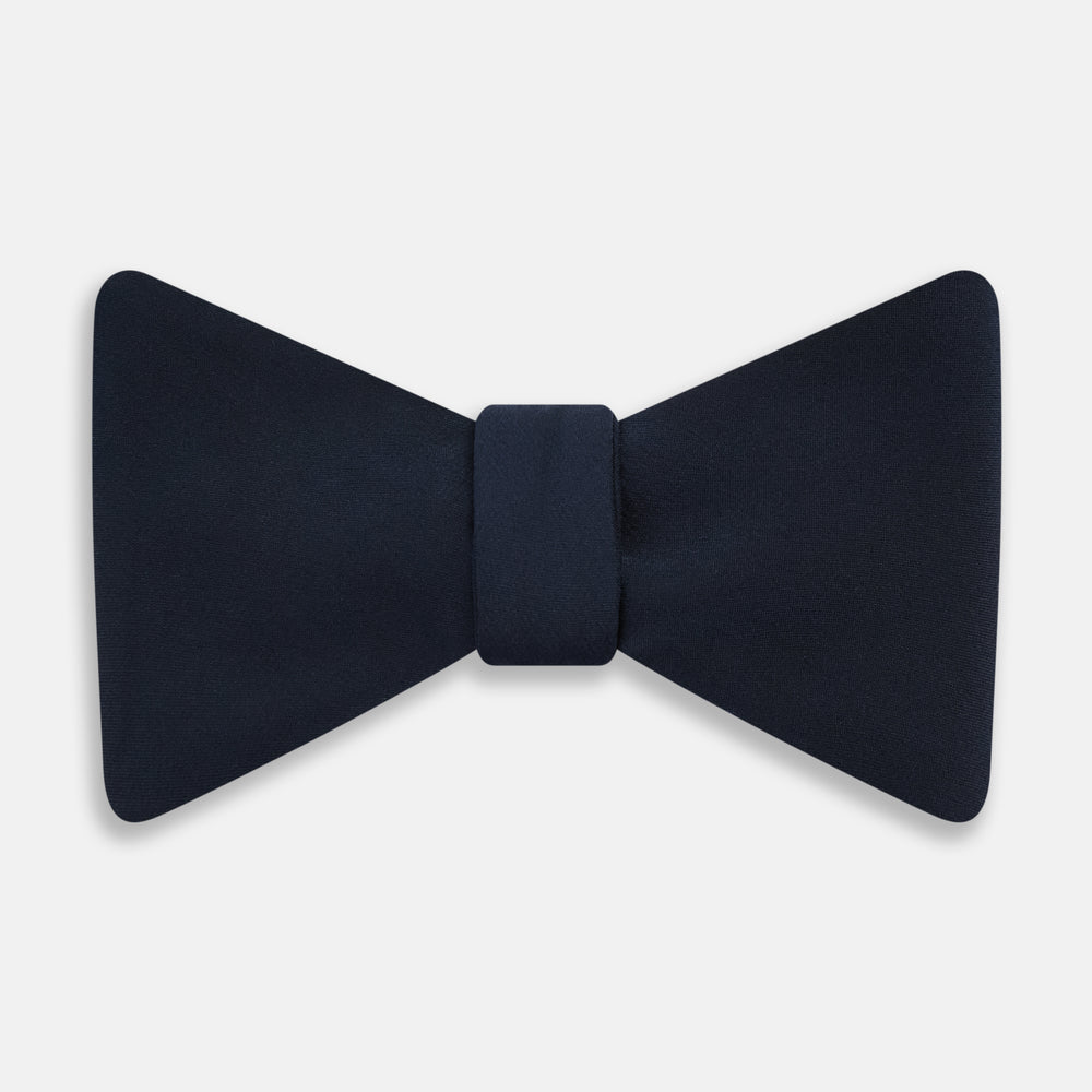 A classic Casino Royale Midnight Blue Bow Tie in silk by Turnbull & Asser UK, crafted from luxurious silk with a smooth texture, is neatly tied and displayed against a plain white background.