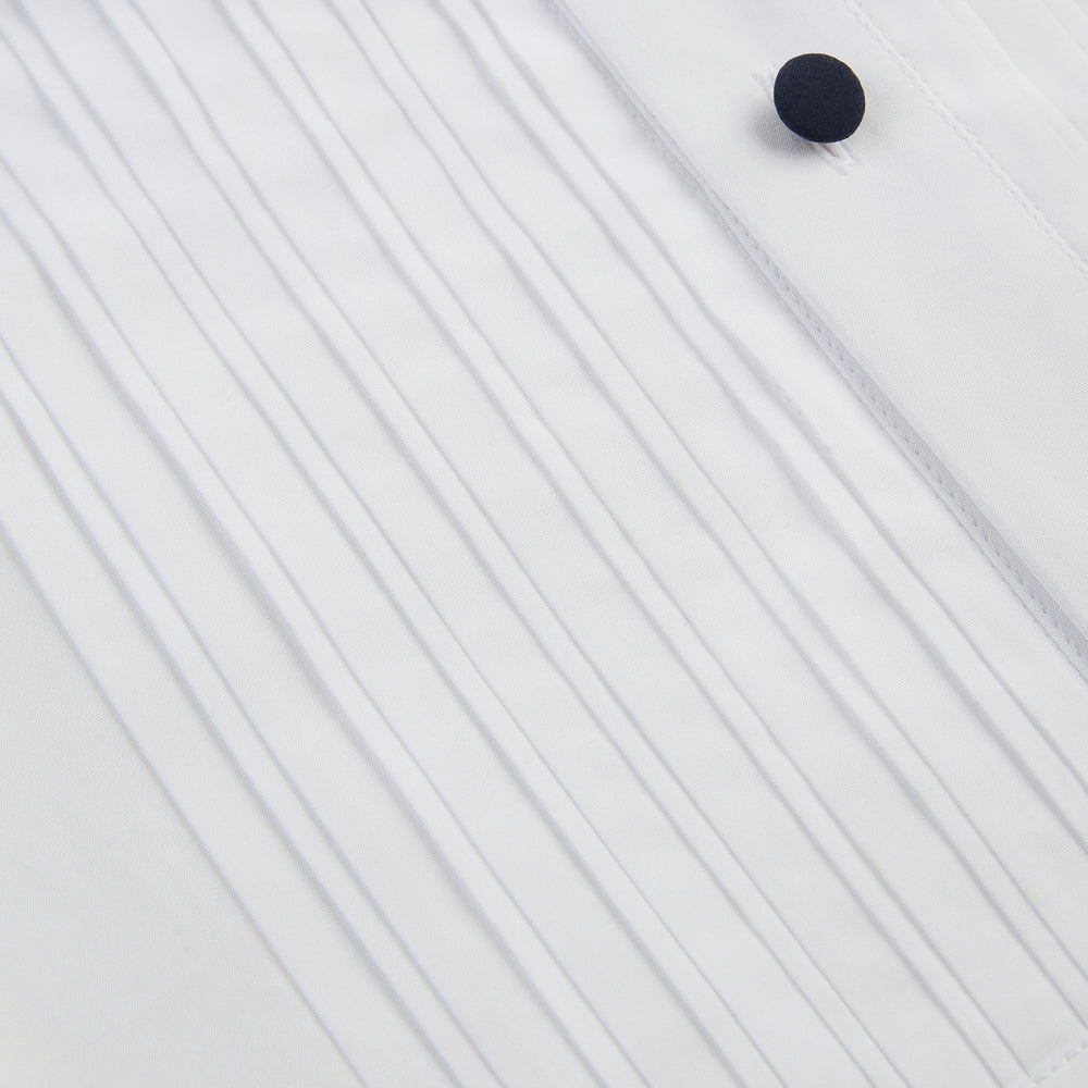 The Casino Royale White Dress Shirt in Cotton by Turnbull & Asser UK is a long-sleeve white dress shirt, crafted from crisp white cotton poplin with a pleated bib front, black buttons, and a classic collar, shown laid flat on a white background.