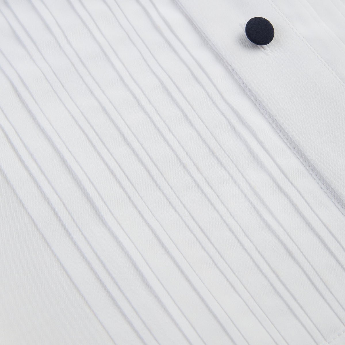 View 7 of product The Casino Royale White Dress Shirt in Cotton by Turnbull & Asser UK is a long-sleeve white dress shirt, crafted from crisp white cotton poplin with a pleated bib front, black buttons, and a classic collar, shown laid flat on a white background.