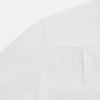 View 6 of product The Casino Royale White Dress Shirt in Cotton by Turnbull & Asser UK is a long-sleeve white dress shirt, crafted from crisp white cotton poplin with a pleated bib front, black buttons, and a classic collar, shown laid flat on a white background.