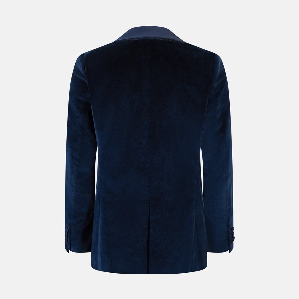 Turnbull & Asser UK’s Casino Royale Midnight Blue Tuxedo Jacket in Cotton Velvet, featuring a single button closure and a luxurious silk-satin shawl lapel, is showcased against a plain white background.