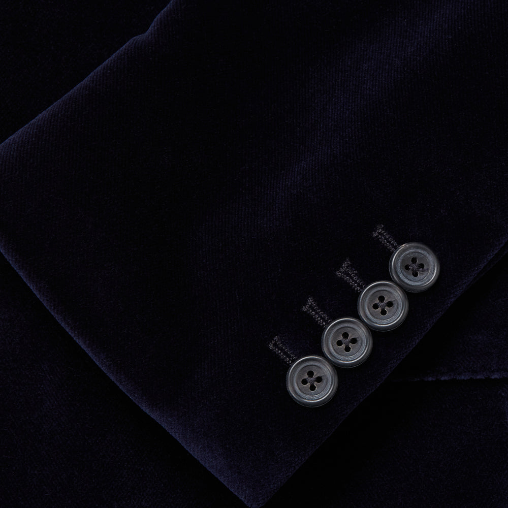 The Turnbull & Asser Navy Velvet Jacket features a classic fit, single-breasted style, notched lapels, two flap pockets, chest pocket, and single button closure. Made in Italy; shown on a plain white background.