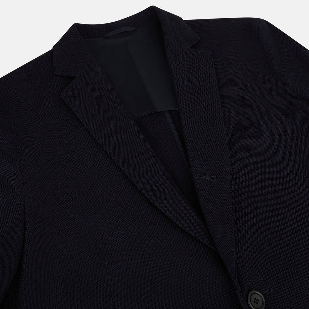 The Navy Knitted London Blazer by Turnbull & Asser features notch lapels, two buttons, and three front pockets—ideal for spring or summer contemporary looks. Displayed on a plain white background.