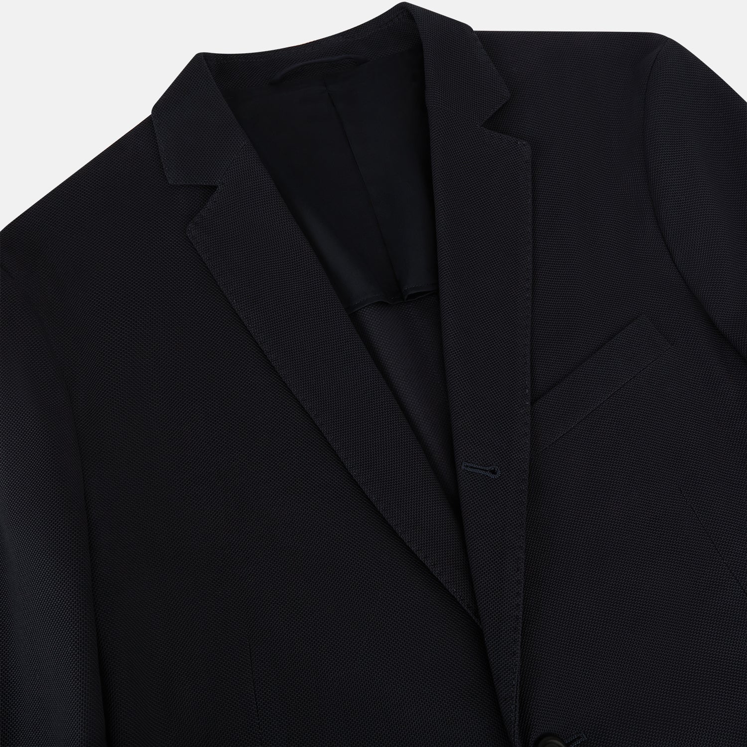 View 2 of product The Charcoal Knitted London Blazer by Turnbull & Asser is a men's single-breasted formal jacket with two buttons, notched lapels, and two front patch pockets, shown against a plain white background.