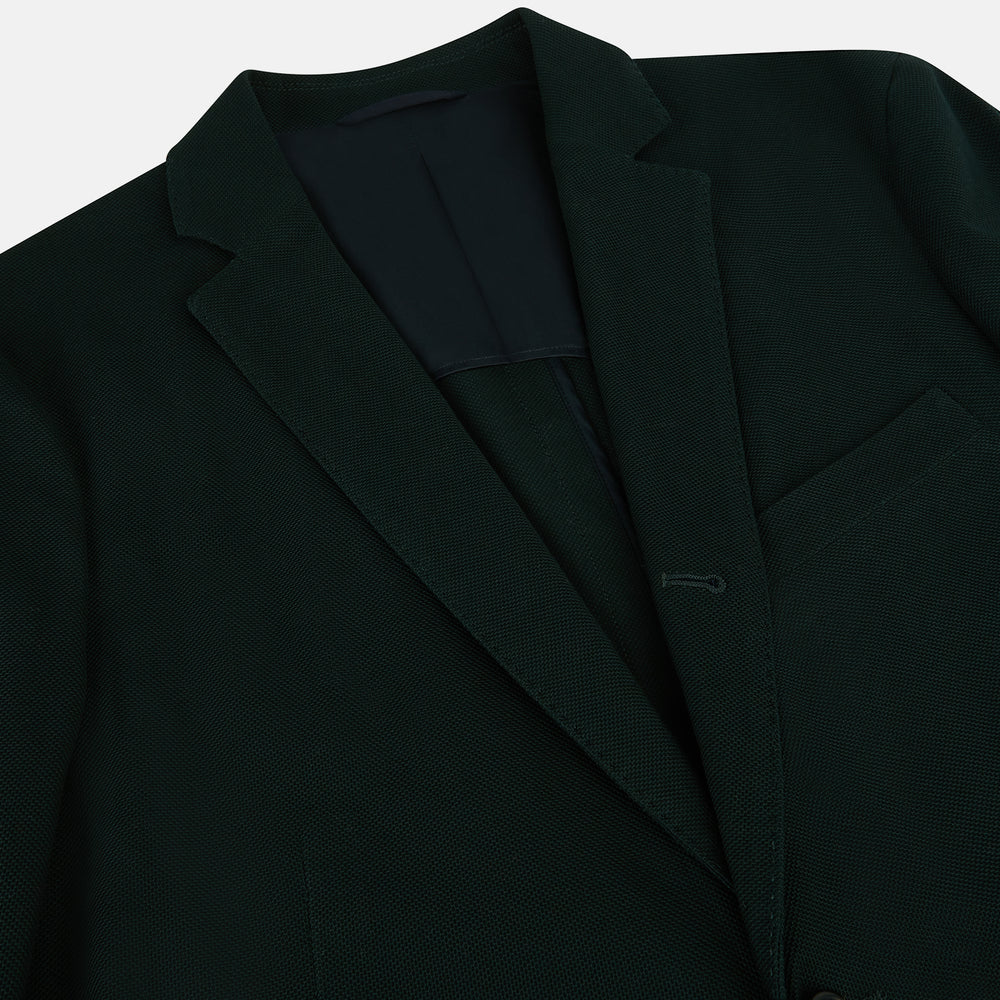 The Turnbull & Asser Forest Green Knitted London Blazer showcases notch lapels, two buttons, patch and chest pockets on a white background—a modern classic for timeless style.