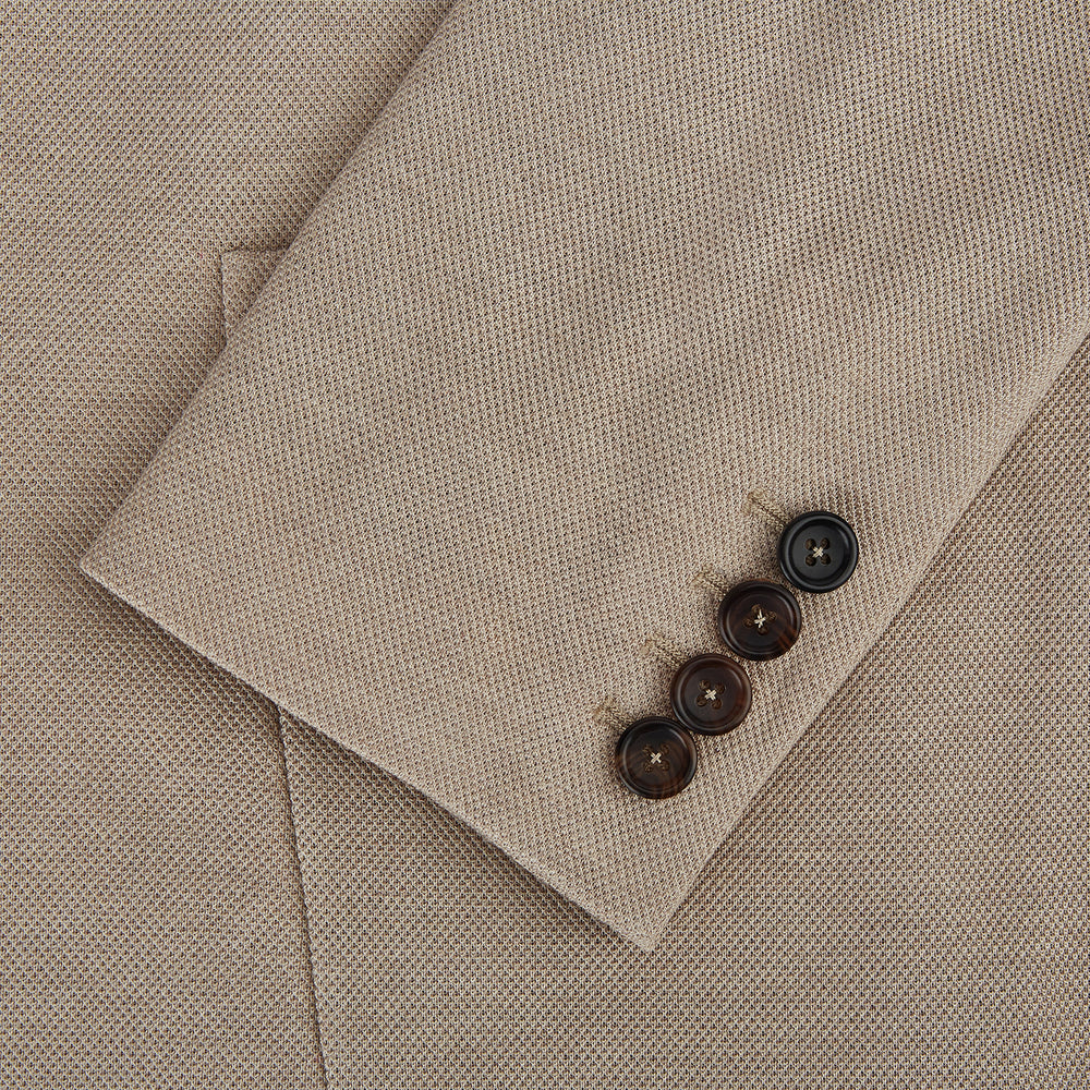 The Turnbull & Asser UK Sand Silk & Cotton Bath Blazer showcases Italian craftsmanship with notched lapels, two front buttons, large patch pockets, and a chest pocket, all set against a plain white background.