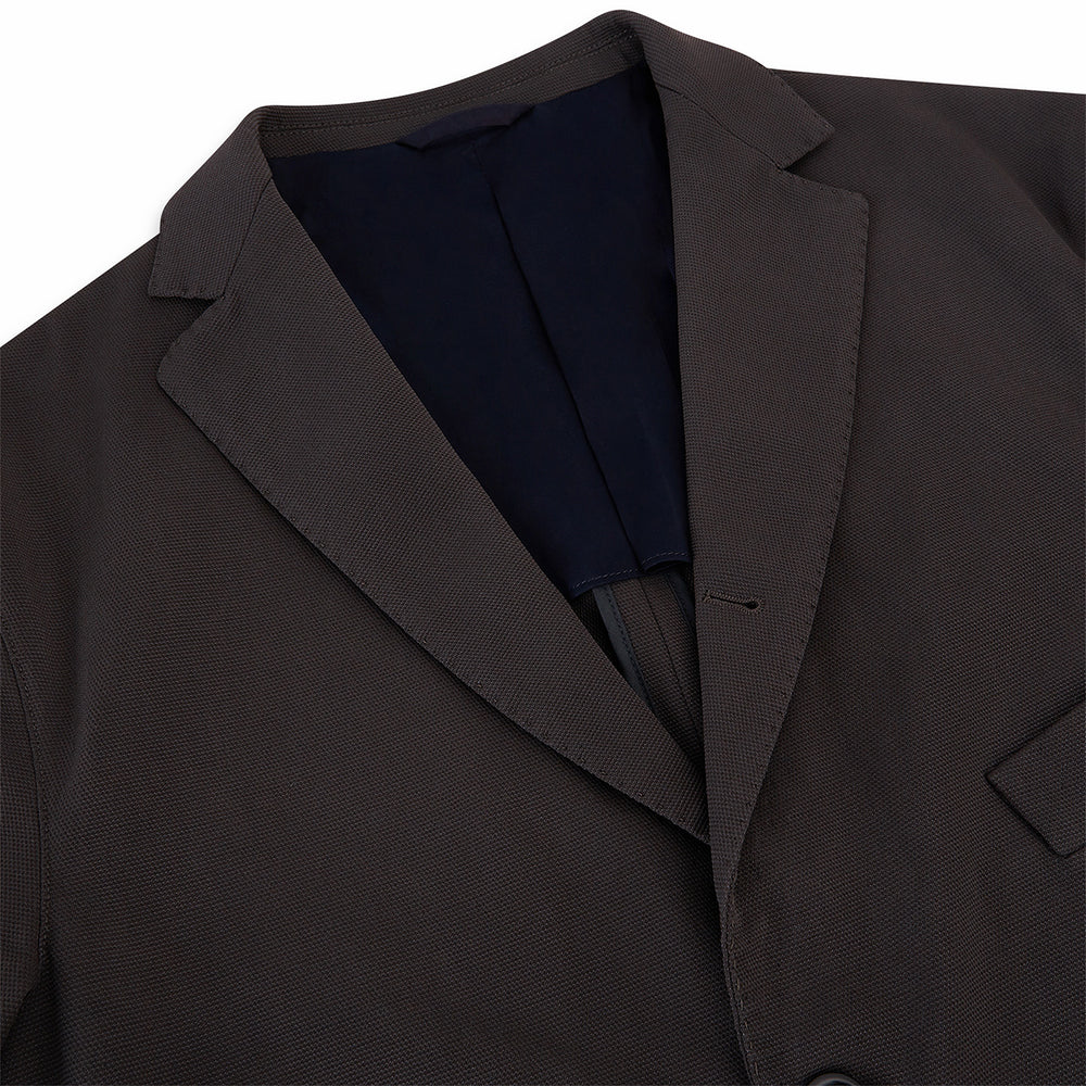 Introducing the Riviera Chocolate Oversized Blazer in Cotton by Turnbull & Asser UK—a dark brown blazer featuring two front buttons, three patch pockets, and notch lapels. Crafted from a cotton-nylon stretch fabric and showcased against a plain white background, this piece is a timeless addition to your autumn wardrobe.