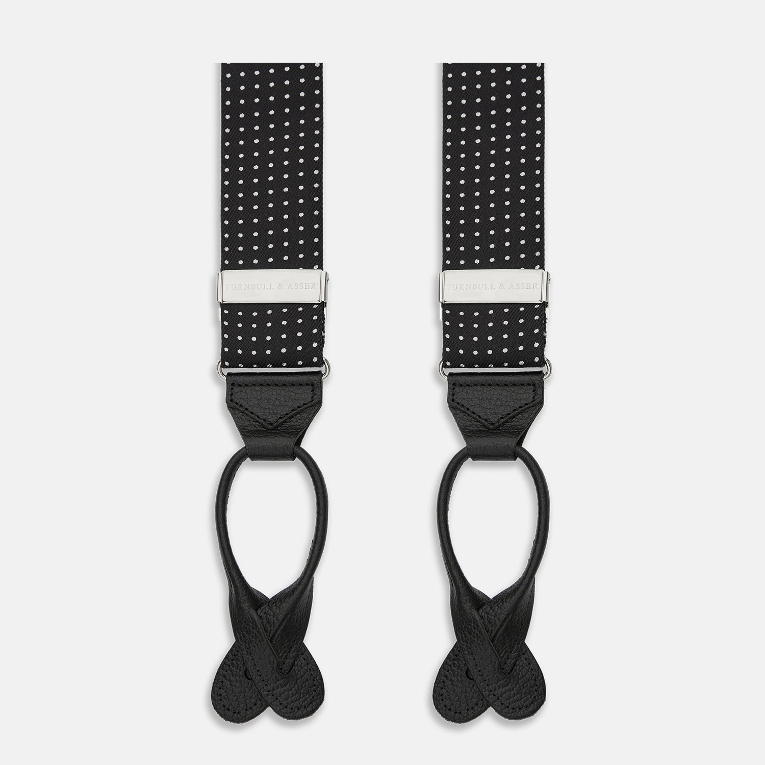 View 1 of product Turnbull & Asser Black & White Small Spot Adjustable Silk Braces with leather loops and silver adjusters, featuring small white polka dots—perfect for refined style and shown against a white background.