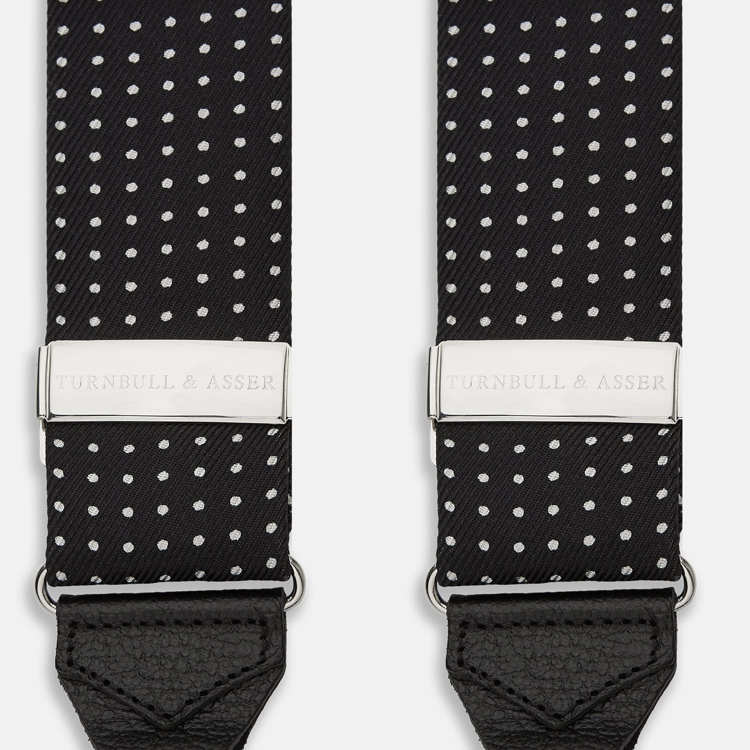 View 2 of product Turnbull & Asser Black & White Small Spot Adjustable Silk Braces with leather loops and silver adjusters, featuring small white polka dots—perfect for refined style and shown against a white background.