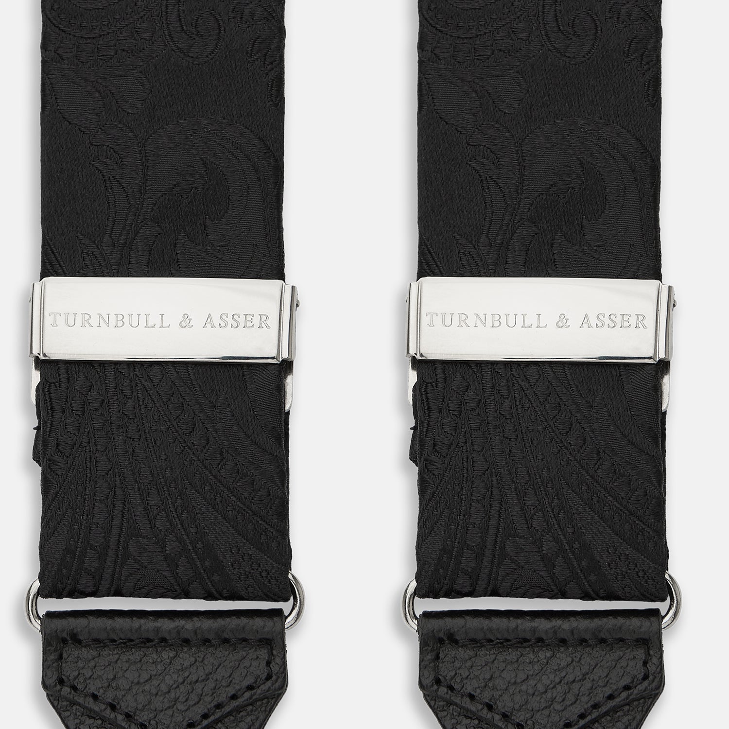 View 2 of product Turnbull & Asser's Black Paisley Adjustable Silk Braces feature silver-tone engraved clips and leather loop ends for button attachment, offering refined style. Shown against a white background.