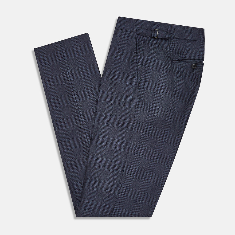 The Navy Check Henry Trousers by Turnbull & Asser are tailored-fit, dark blue pants with a subtle check pattern, front pockets, button closure, and belt loops, crafted from premium Italian wool and displayed on a plain white background.