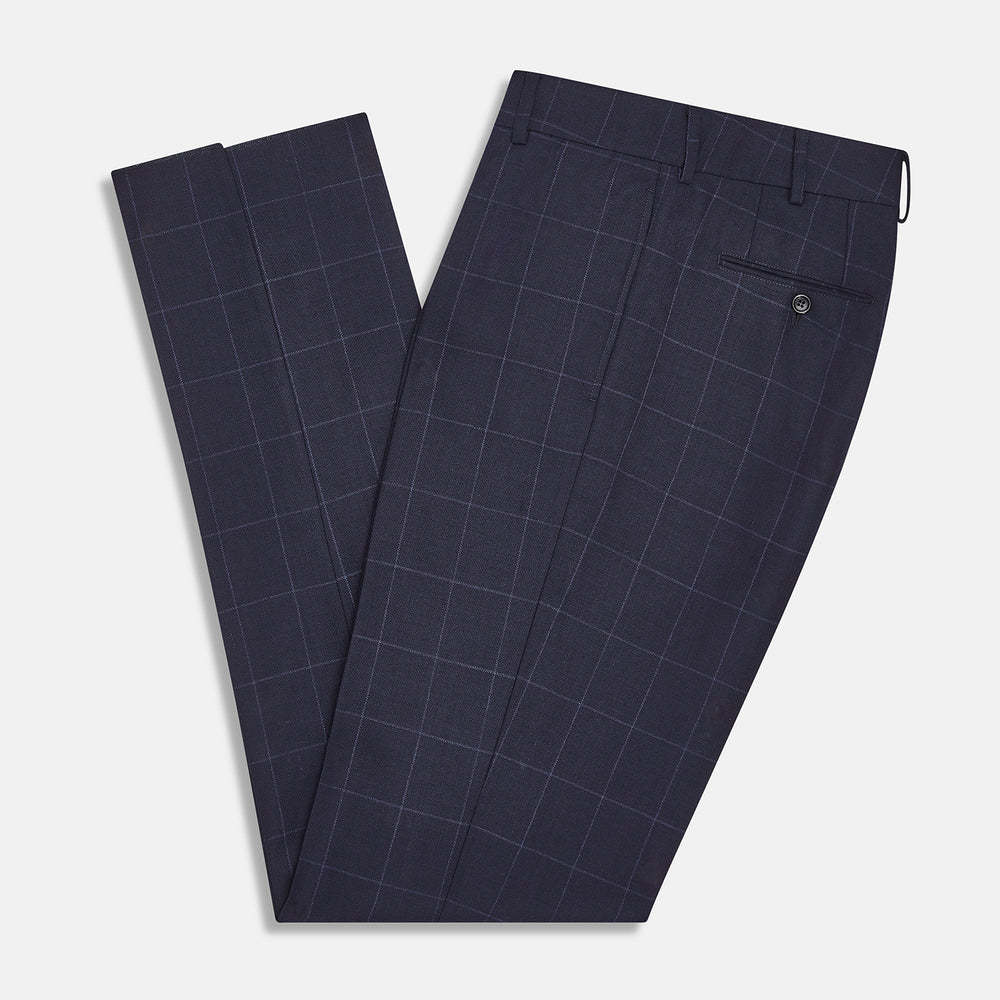 Turnbull & Asser Navy Check Edward Trousers feature a subtle white windowpane pattern, pleated front, belt loops, and button closure, shown against a plain white background.