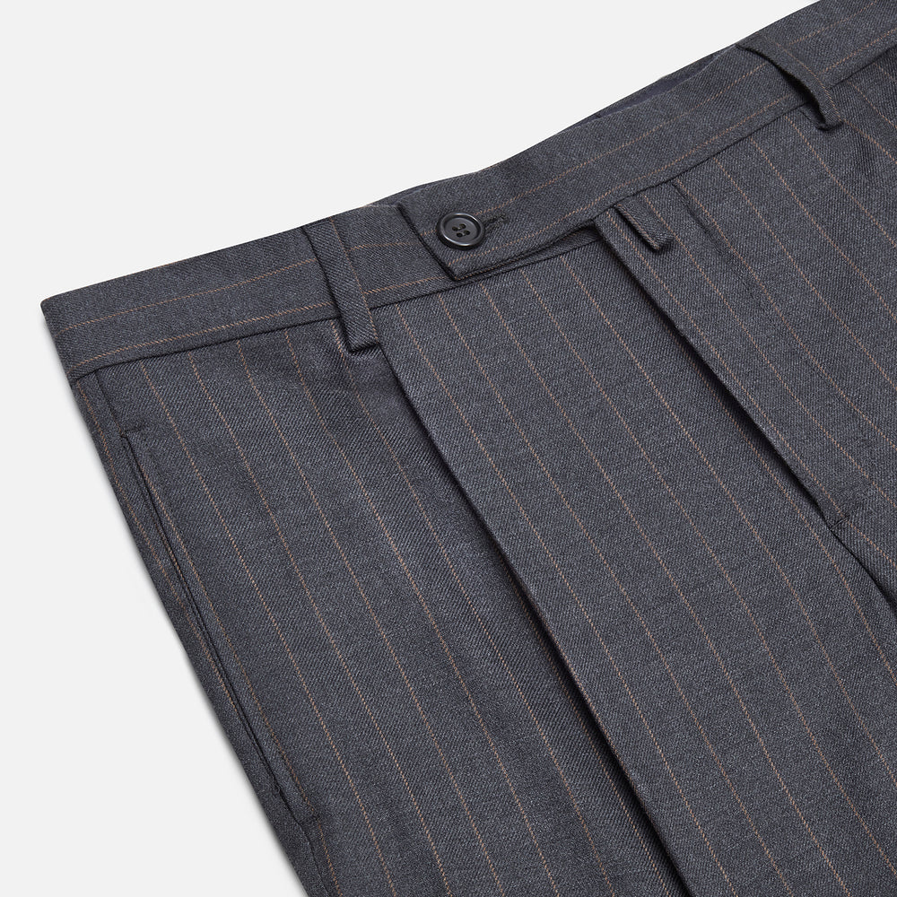 The Turnbull & Asser Dark Grey Pinstripe Arthur Trousers feature a subtle pinstripe, front button and zip closure, belt loops, and pleated front. These straight-leg trousers are shown against a plain white background.