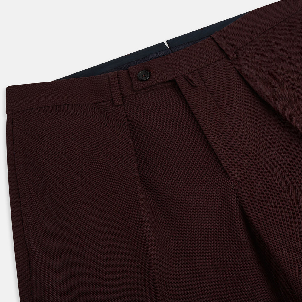 A pair of Burgundy Knitted London Trousers by Turnbull & Asser, featuring a tailored fit, button closure, front pleats, belt loops, and straight legs, displayed on a plain white background.