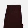 View 5 of product A pair of Burgundy Knitted London Trousers by Turnbull & Asser, featuring a tailored fit, button closure, front pleats, belt loops, and straight legs, displayed on a plain white background.