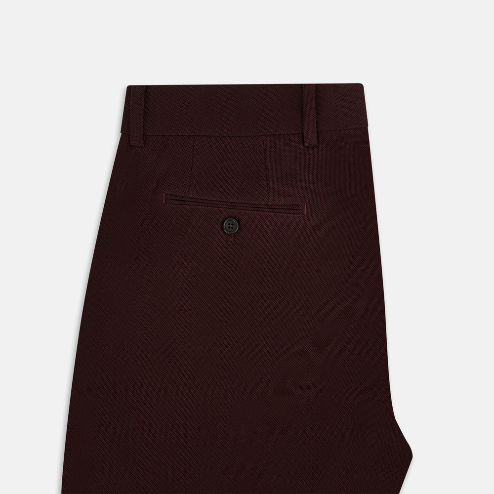 A pair of Burgundy Knitted London Trousers by Turnbull & Asser, featuring a tailored fit, button closure, front pleats, belt loops, and straight legs, displayed on a plain white background.